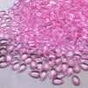 A pile of pink water drop Czech glass beads for jewelry making.
