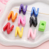 A collection of colorful acrylic letter beads shaped like the letter N arranged on a white tray.