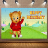 A cute cartoon tiger character with a red hoodie celebrating a happy birthday against a green outdoor background.