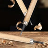 A close-up of a professional wood carving chisel set with light wood handles and steel blades resting on a wooden surface.