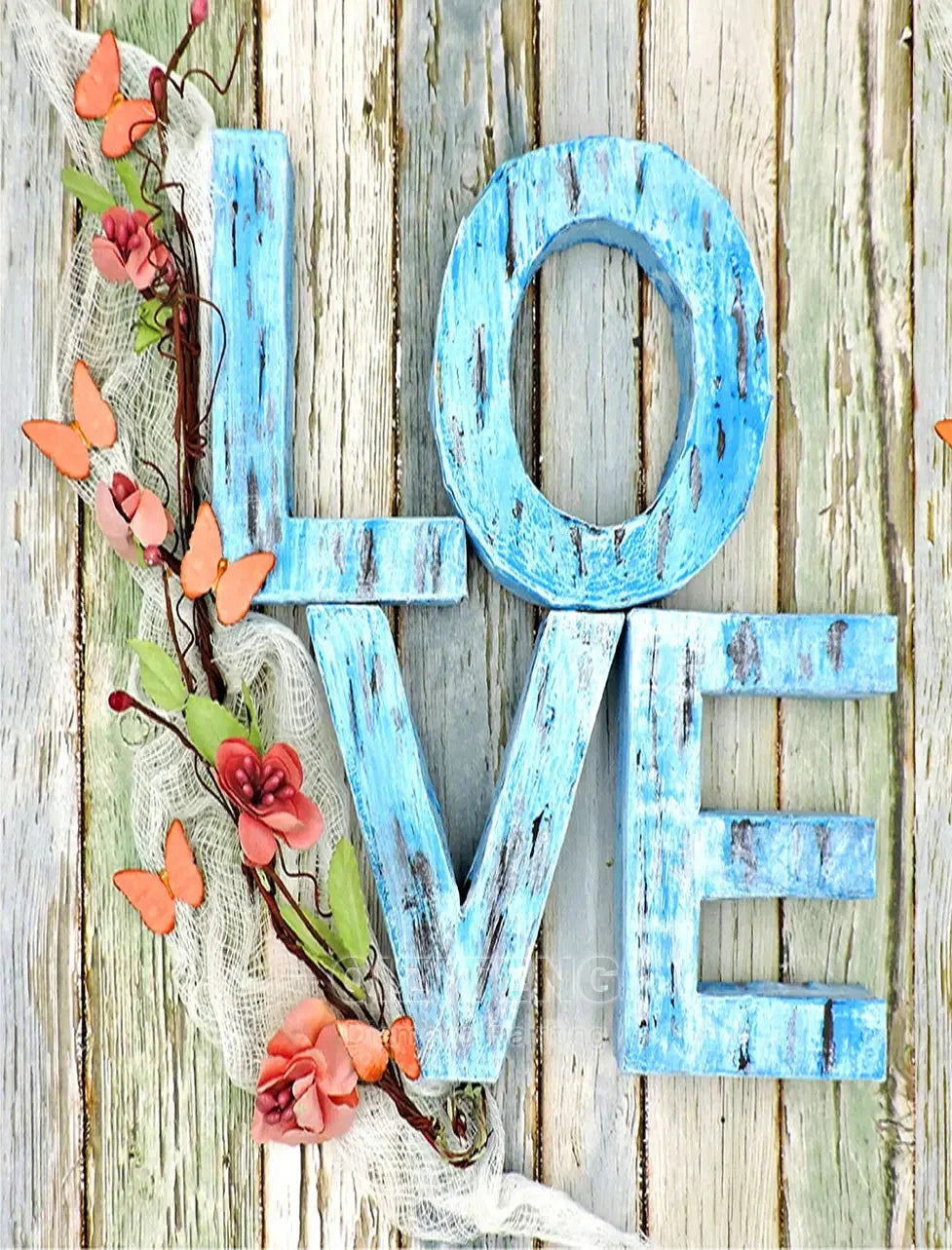 Wooden letters spelling LOVE made of distressed blue wood with pink floral vines