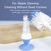 A white bottle cleaning brush with a suction stand is shown on a wooden board.