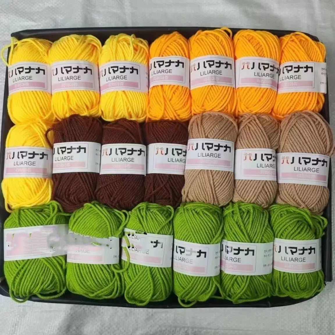 A pack of 20 skeins of various colored yarn including yellow, orange, brown, and green wool for knitting and crafts
