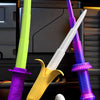 A set of three colorful plastic katana-style toys, including a lime green and yellow blade, purple and white blades, and a wh