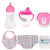 A set of pink and white doll feeding accessories including a bottle, cup, and silicone spoons.