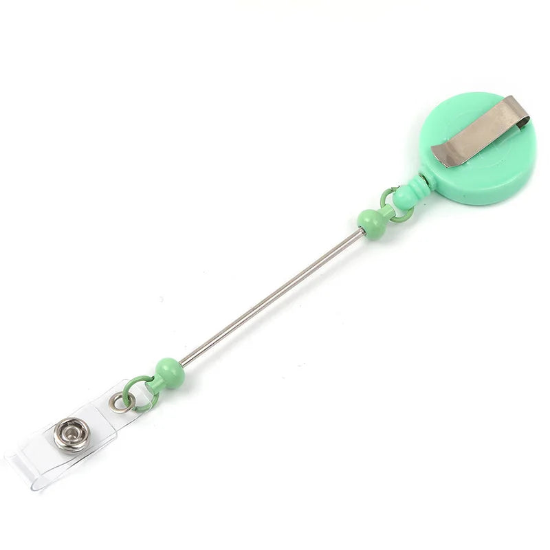 A beadable badge reel with a retractable clip and decorative green plastic holder.
