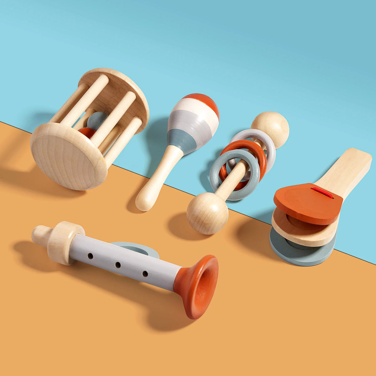 A collection of wooden hand bells and sensory toys in natural wood tones and orange colors on a light blue background.