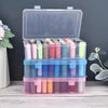 Transparent sewing thread organizer with four compartments holding various colored bobbins.