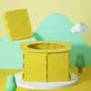 A yellow foldable baby potty training seat is shown on a light green surface with a yellow cloud in the background.