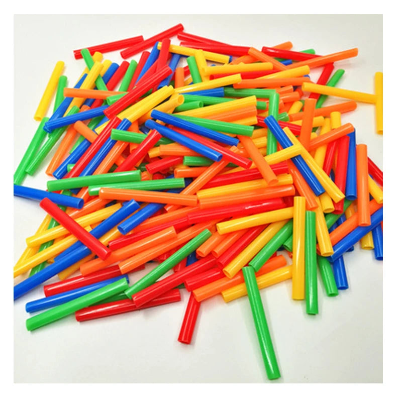 A pile of colorful interlocking building straws and connectors in various bright colors like red, yellow, green, and blue.