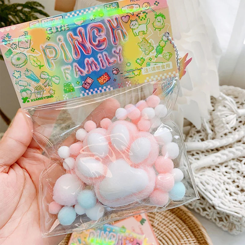 A clear plastic bag contains a cluster of pink and white squishy toys shaped like cat paws.