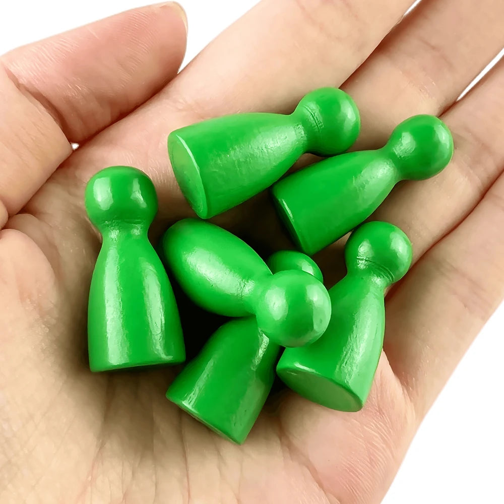 A hand holds a set of twelve wooden game pawns in various shades of green.