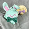 A light green chibi plush keychain of Alien Stage Ivan with pink ears and a green bow, next to a yellow chibi plush.