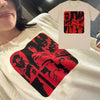 A close-up of a white t-shirt featuring a red graphic print on the chest and a matching design on a separate shirt.