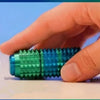 A hand holds a green spiky fidget roller stress relief keychain.