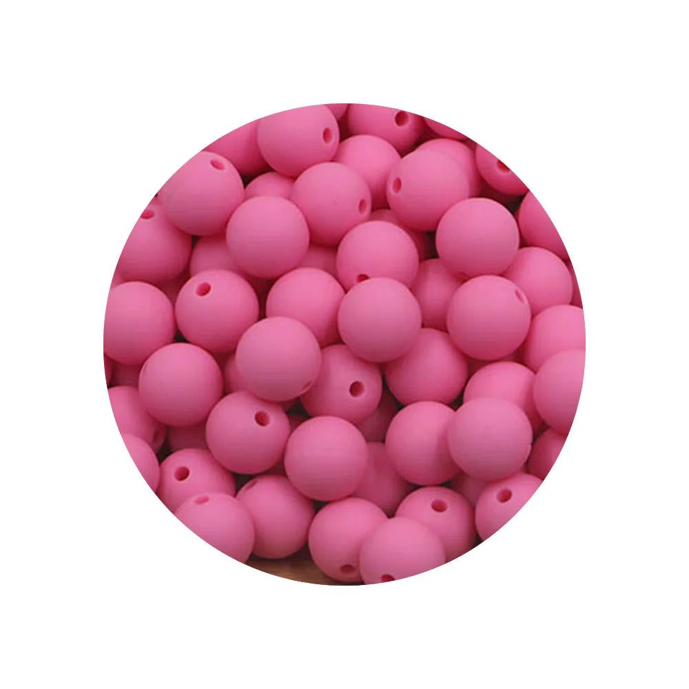 A circular arrangement of pink silicone beads in various sizes for DIY jewelry making