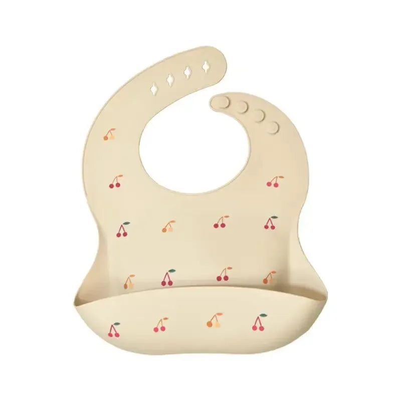 A light beige silicone baby bib with an adjustable neck and small fruit pattern.