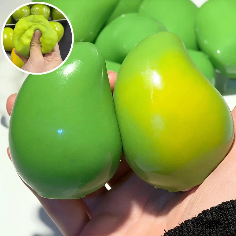 A hand holds a bright green, oval stress ball next to a small bowl of green mango pieces.