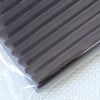 A close-up view of a dark gray polymer clay kit with ribbed texture, packaged in clear plastic.