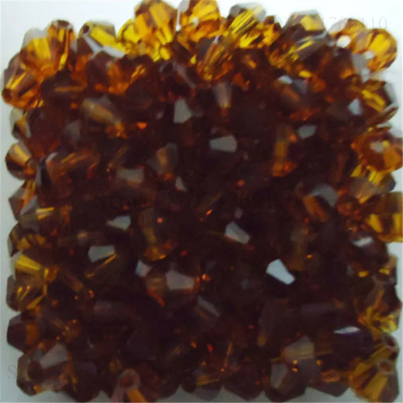 Un amas de perles de cristal couleur ambre utilisées pour la fabrication de bijoux DIY.