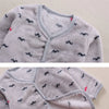 A close-up of a light gray fleece jacket and pants set for a baby with black cartoon animal prints.