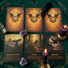 A set of oracle cards featuring dark, mystical imagery and purple crystals laid on a green fabric.