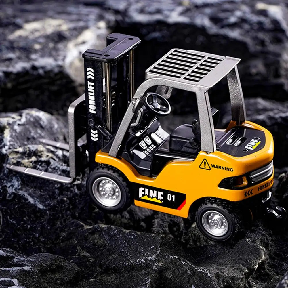 Un mini-camion chariot élévateur télécommandé jaune est montré sur une surface rocheuse sombre.