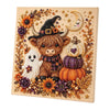 A framed canvas featuring a detailed illustration of a witch, a sheep, and various autumnal floral elements and pearls.