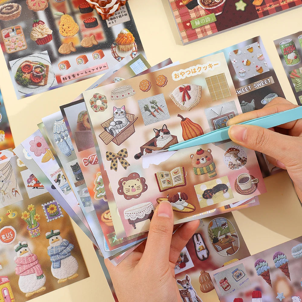 A hand holds a stack of Kawaii embroidery-style sticker sheets featuring cute animal and food designs.