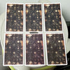 Un paquet carré de cartes oracles de tarot avec des images vieilles et sombres et des accents dorés.