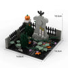 A gray haunted house building block set featuring a stone structure, dark fencing, and green foliage for DIY Halloween decor.