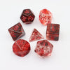A collection of red crystal-style polyhedral dice, including a dodecahedron and a tetrahedron, scattered on a white backgroun