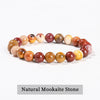 A bracelet made of natural pink quartz stones in various shades of pink, orange, and yellow.