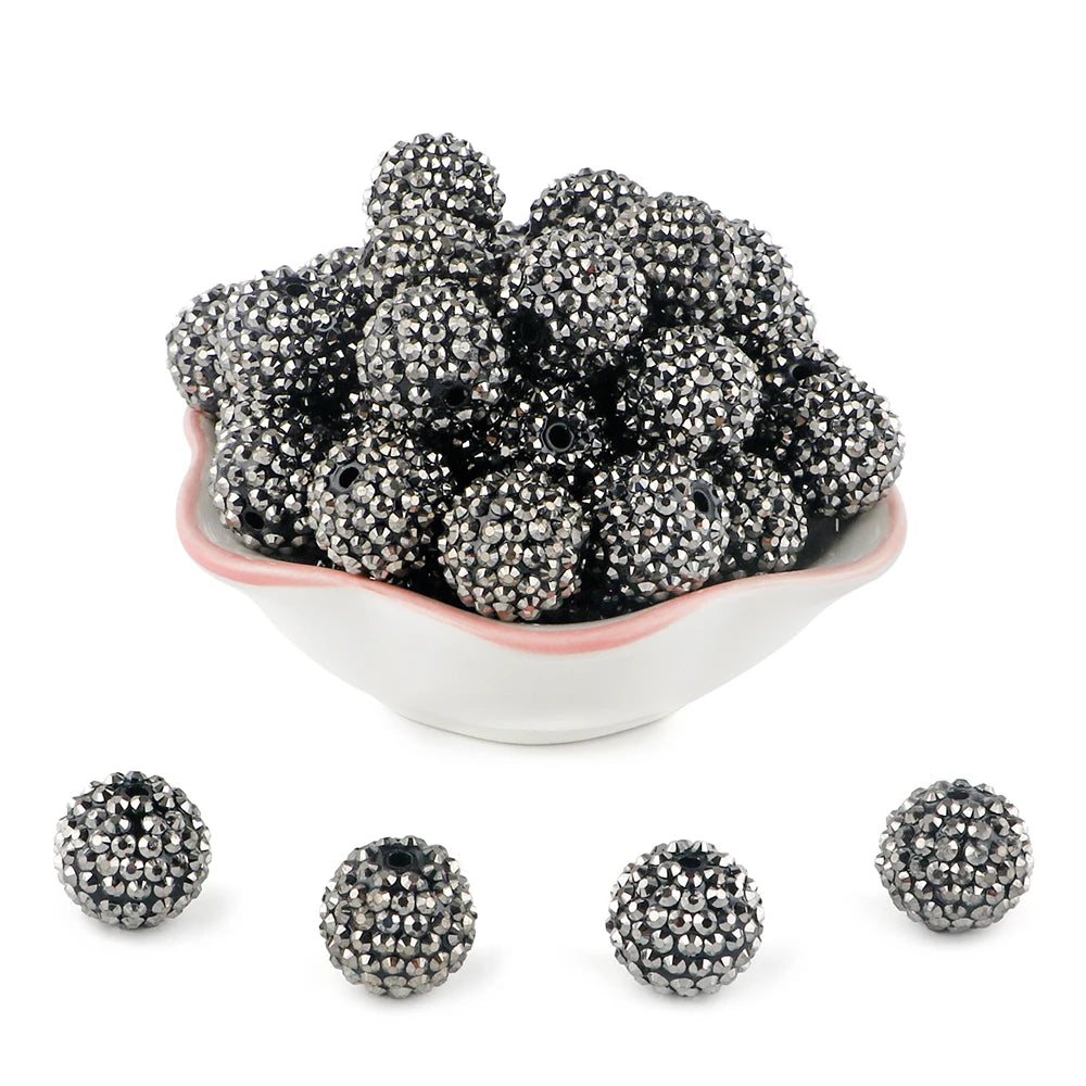 A pile of black and silver rhinestone resin bayberry beads for jewelry making.