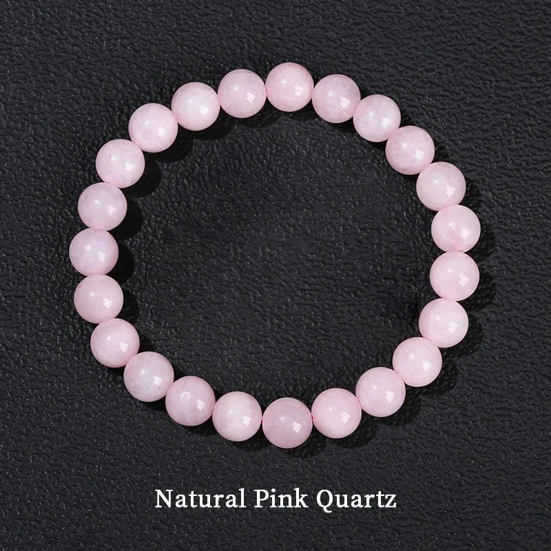 A bracelet made of smooth, round natural pink quartz beads arranged in a circle.