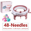 Pink hand-operated knitting machine with 48 needles, yarn rolls, and packaging box.