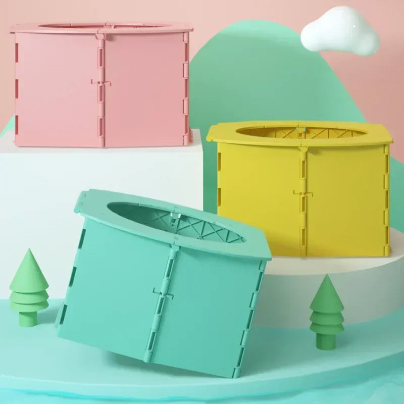 Three colorful foldable baby potty training seats in pink, yellow, and teal displayed on a light background.