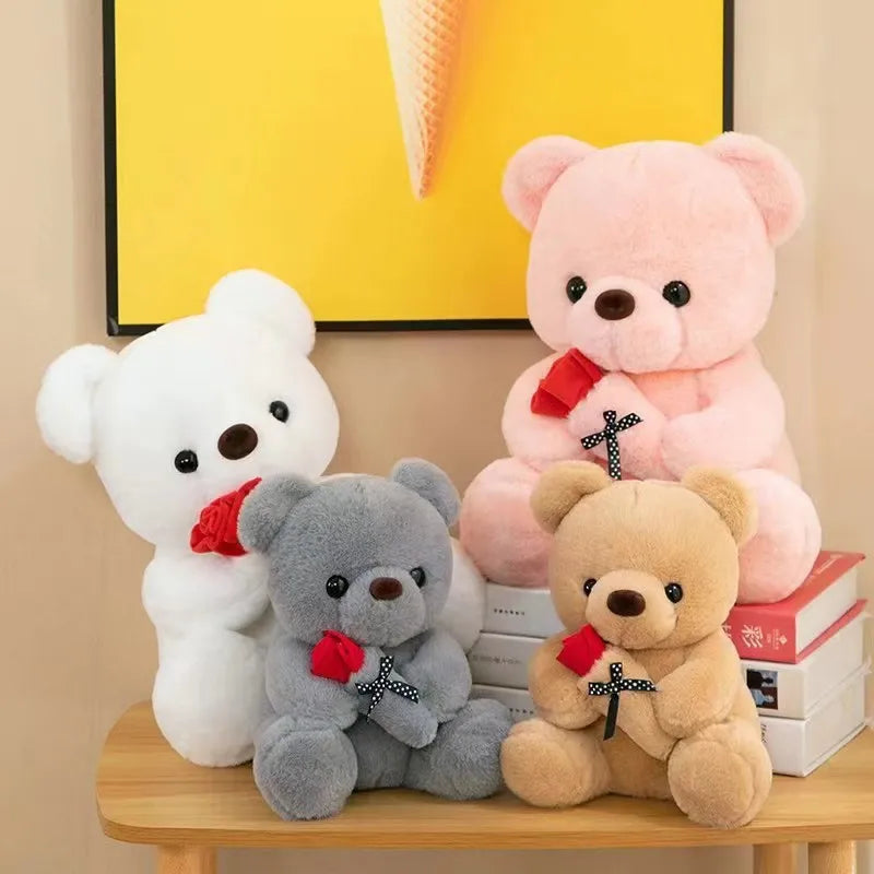 A collection of plush bears in white, pink, and gray colors displayed on a wooden surface.