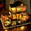 A detailed wooden dollhouse with furniture and internal LED lighting, displayed on a dark surface.
