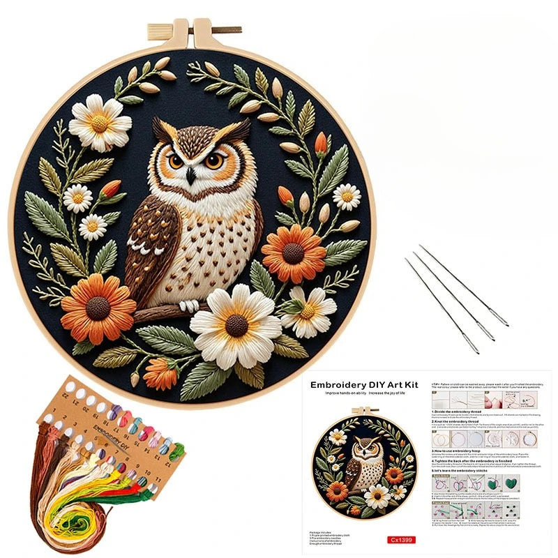 DIY embroidery kit featuring an owl and flower design on a dark fabric with threads and tools