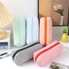 A collection of striped canvas pencil cases in mint green, light blue, and orange are displayed on a white surface.