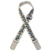 A beige woven guitar strap with blue floral embroidery and leather accents.