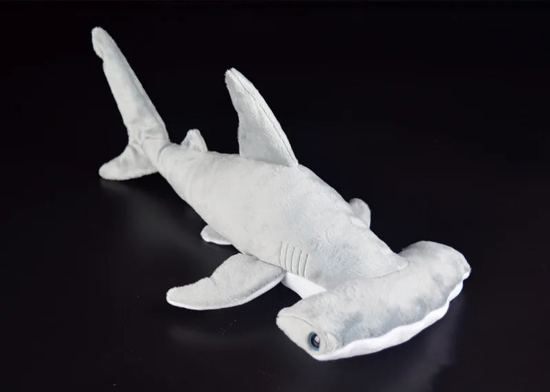 A white super soft hammerhead shark plush toy is shown against a dark background.