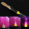 A wooden and black LED crochet hook set with interchangeable yellow tips shown against a pink yarn background.