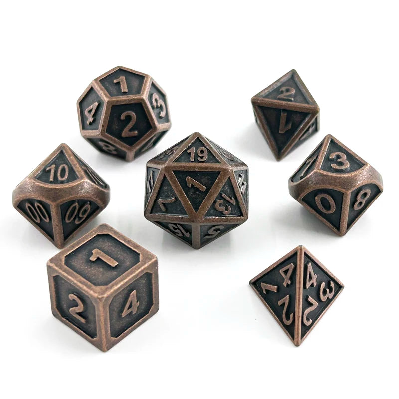 A set of ten metal polyhedral dice with a bronze finish scattered on a white background.