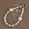 A necklace featuring pink and clear pearls and a star charm, displayed against a brown background.