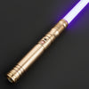 A close-up of a gold lightsaber with a glowing purple blade and a metallic hilt against a dark background.
