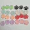 A collection of 50 small, flatback rose-shaped flowers made from resin in various shades of green, gray, white, and pink.