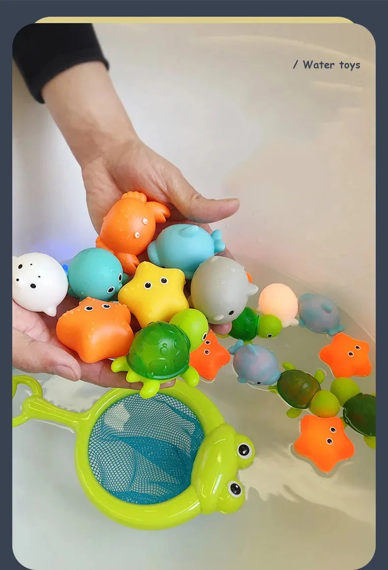 A hand is placing various glow-in-the-dark plastic animal toys into a white basin of water.