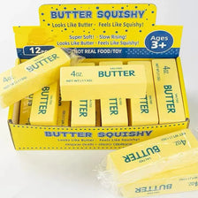 A box of Butter Squishy toys in yellow packaging with various butter-shaped squishies inside.